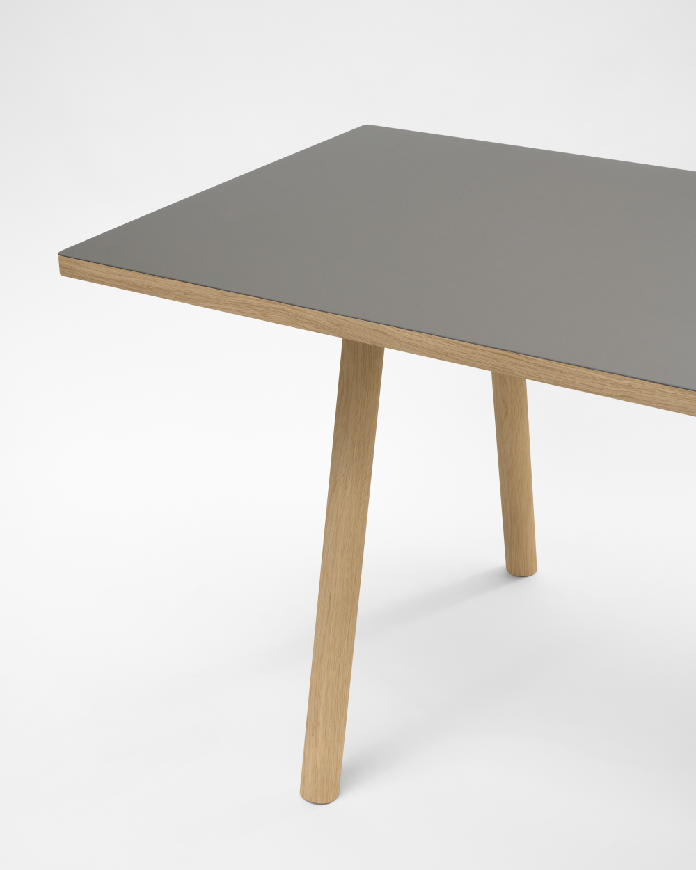 Round DIN PLUS table leg by Faust, made of larch wood with grey linoleum tabletop against a white background.