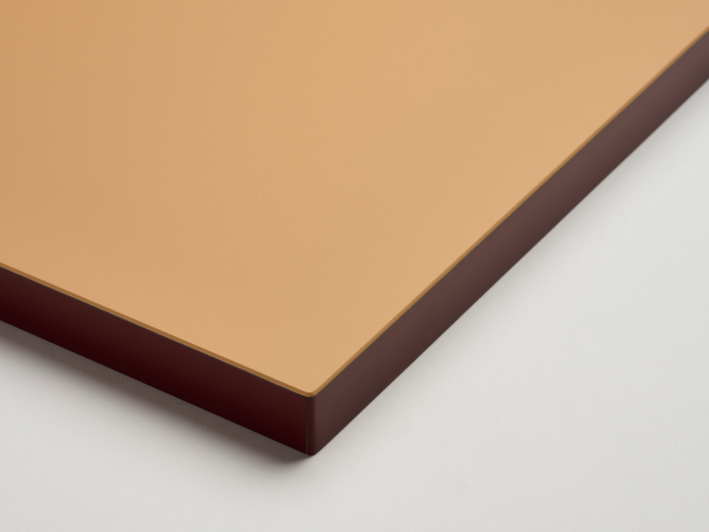 Detail of a Faust table top with matt linoleum surface in leather brown and smooth ABS edge in dark burgundy red.