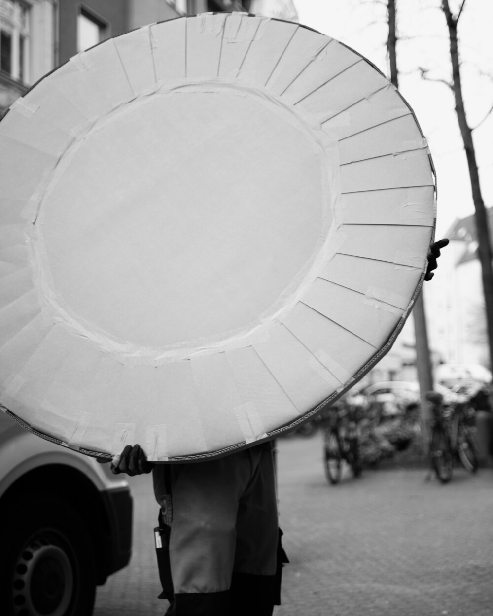 Verpackte runde Tischplatte wird auf der Straße getragen – dokumentiert den Transportvorgang einer Lieferung von Faust Linoleum.