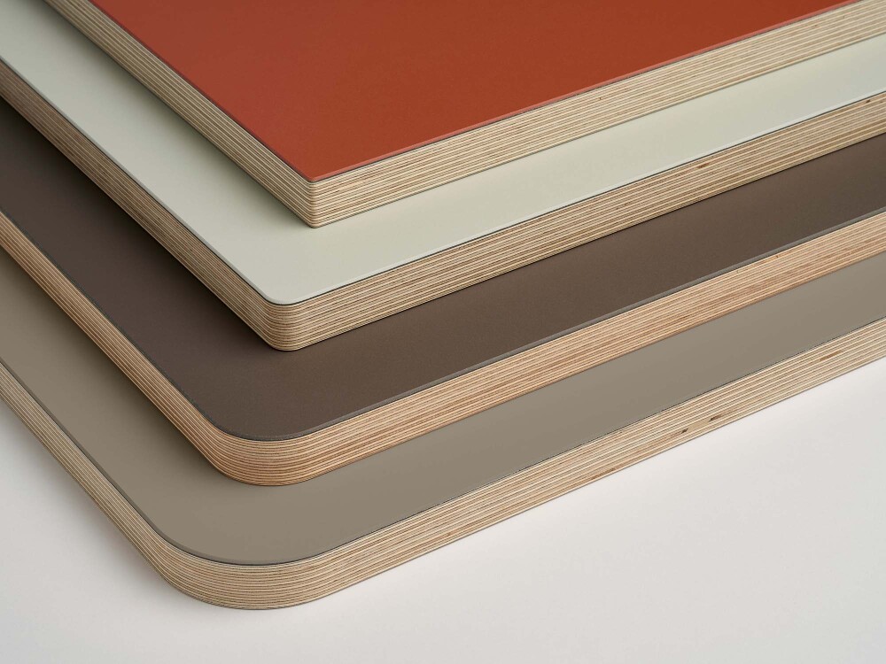 Stacked linoleum table tops from Faust in the colors Brick, Vapour, Mauve, Taupe with different corner radii.