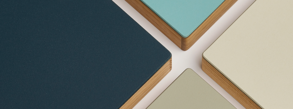 A group of tabletop corners featuring wooden edges and linoleum surface in midnight blue, mushroom, pistachio, and aquavert shades.