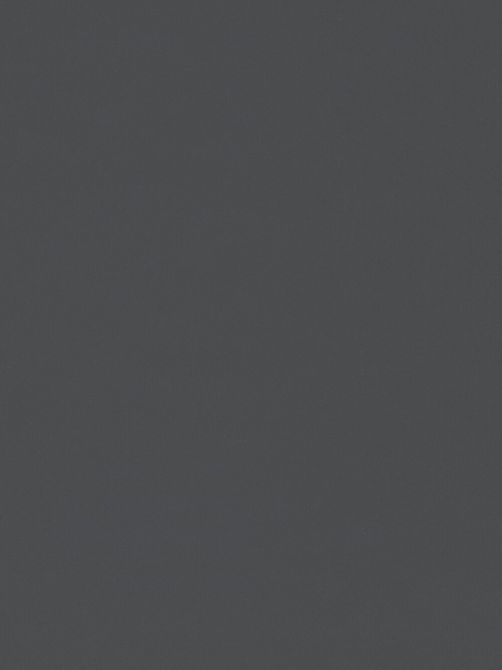 Linoleum-Oberfläche von Faust in Basalt – dunkler, matter Grauton mit feiner Struktur, gezeigt als Nahaufnahme einer Tischplatte.