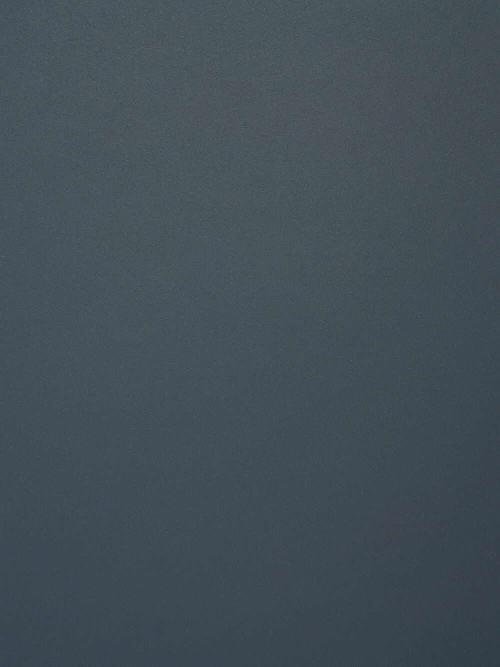 Linoleum-Oberfläche in Smokey Blue – matter, fein texturierter Belag in gedämpftem Dunkelblau, gezeigt als Faust-Materialdetail.