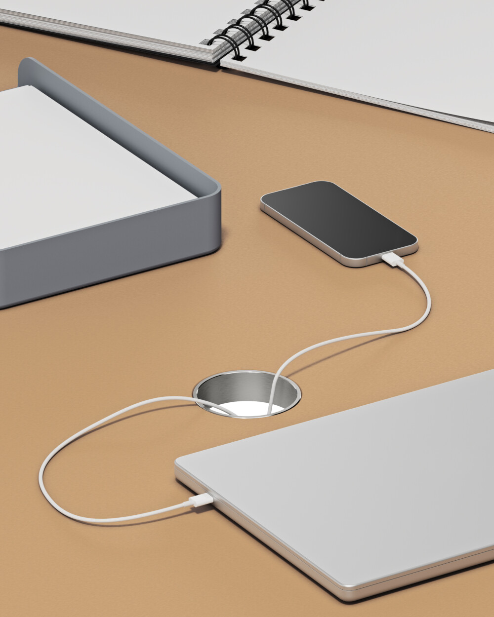 Aluminum cable outlet, round and embedded in linoleum tabletop from Faust - with visible charging cables for laptop and smartphone.