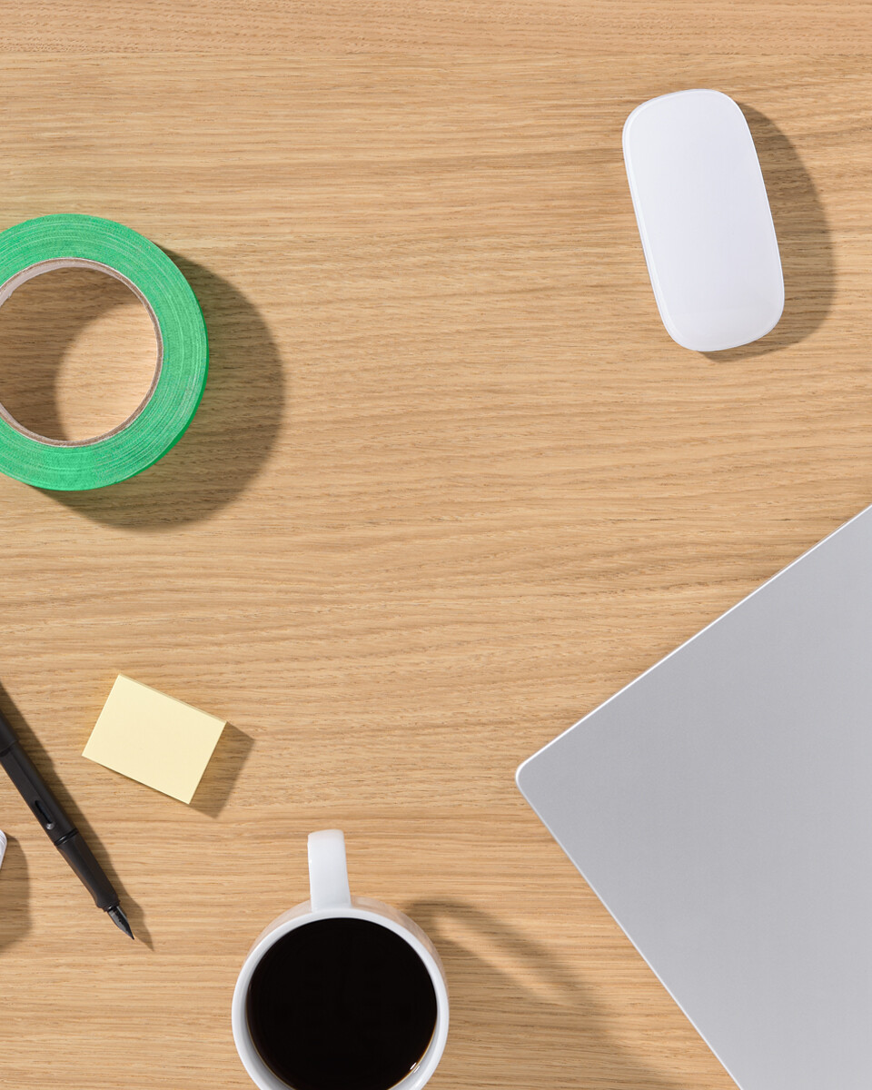 Oak veneer tabletop from Faust with laptop, coffee cup, color fan, pen and adhesive tape - view of a workplace.