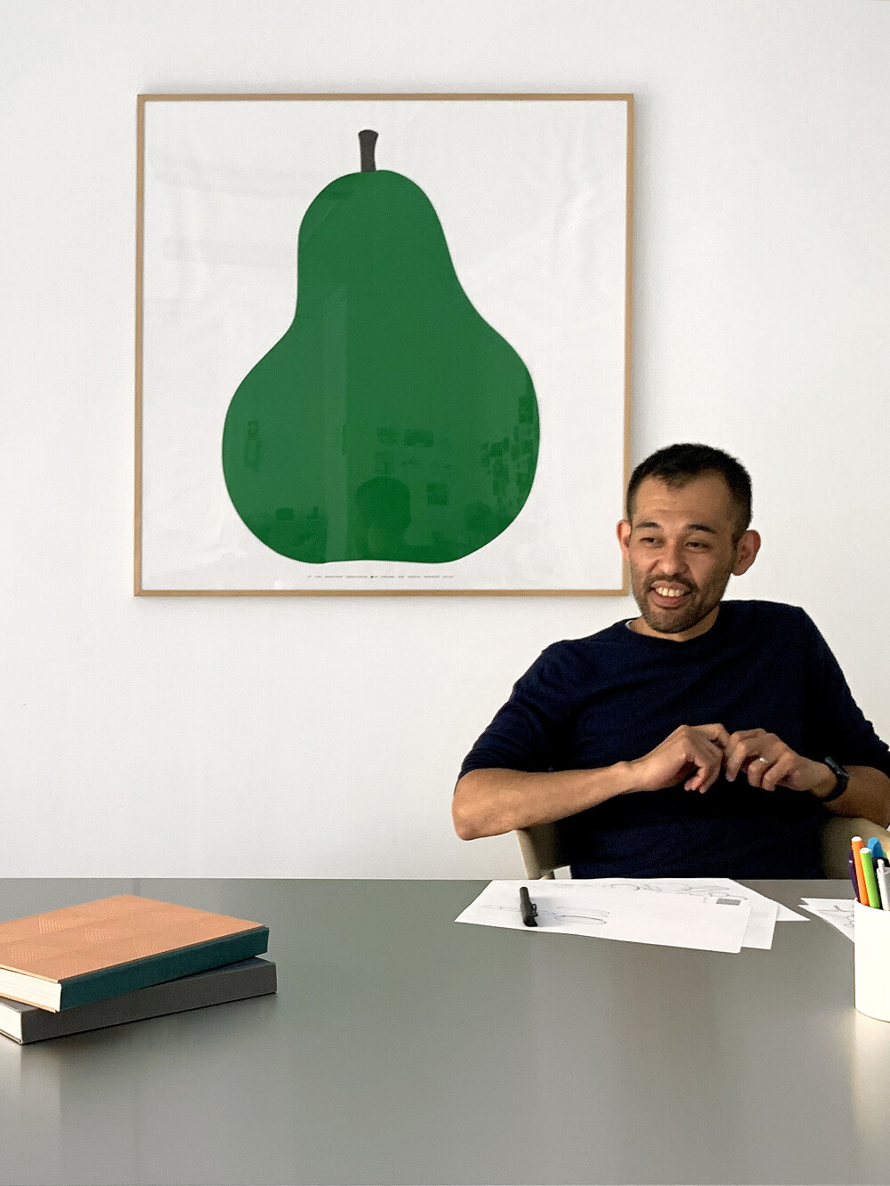 Portrait of Keiji Takeuchi in his Milan studio - seated at a work table with documents, photographed for Faust.