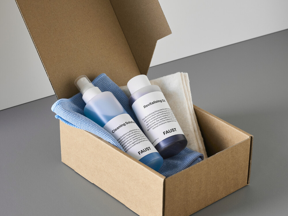 Reinigungs- und Pflegekit von Faust für Linoleum und Holzfurnier – mit Tüchern, Öl und Reiniger in geöffneter Kartonverpackung.
