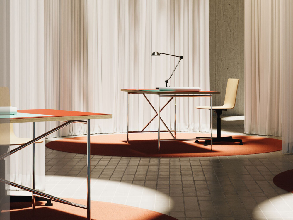 Two E2 desks with terracotta-colored linoleum tops in a light-filled room with white curtains and designer chairs.
