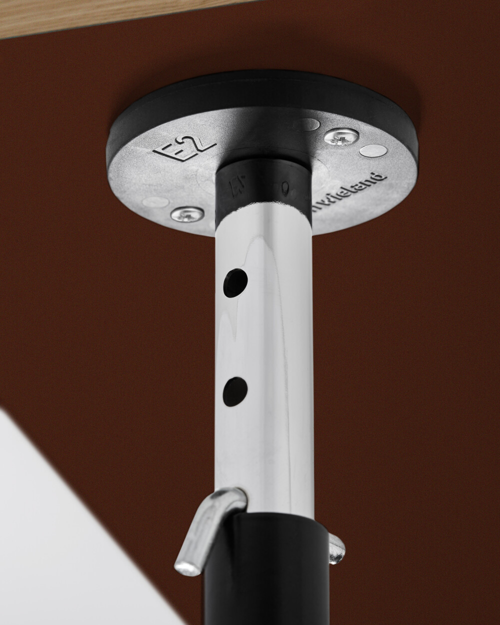 Detailed view of a short height adjuster leg with external leg caps for the E2 table framePlate holder on the E2 frame, stabilises and protects a paper-coated table slat with coating on both sides.