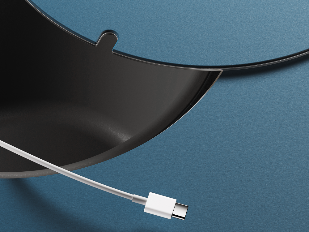 Detailed view of a round cable grommet in the ALT table, from which a USB-C cable is routed out.