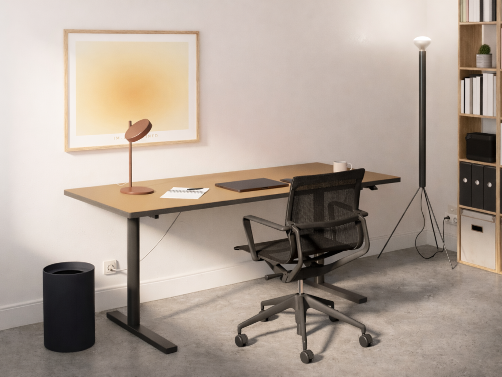 Height-adjustable ATS desk with walnut-colored top and black frame in a modern home office with swivel chair.