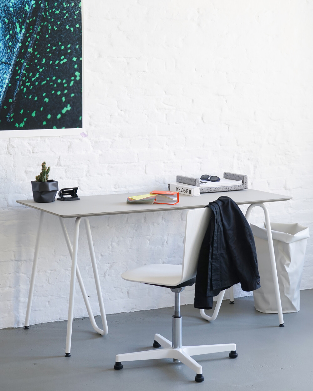 Minimalist desk with Sinus table trestles made of bent tubular steel, designed by Daniel Lorch.